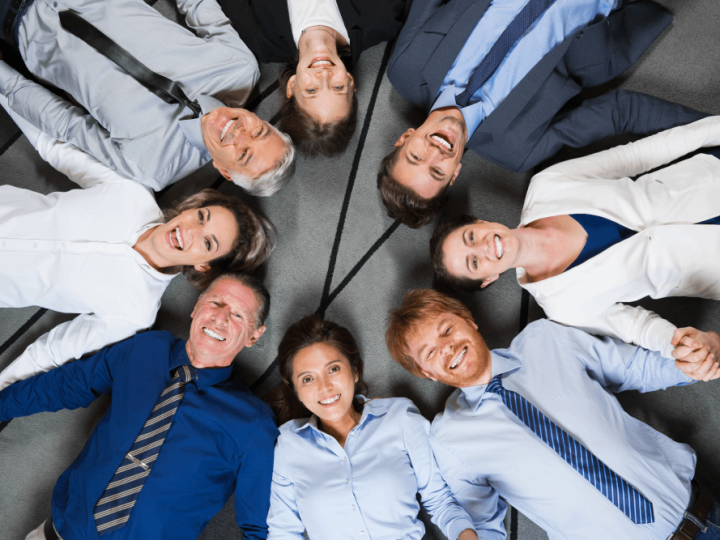 smiling-business-team-lying-floor-circle